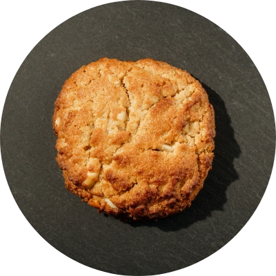 A single peanut butter cookie, placed on a dark background.